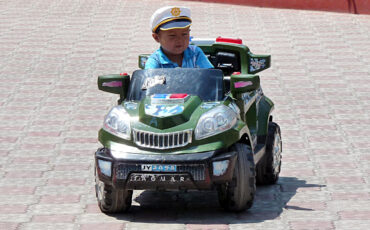 child in a toy car