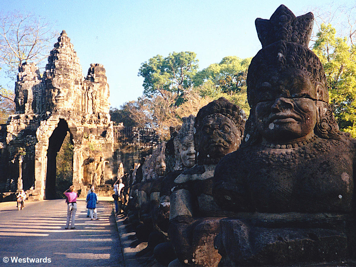 Gate of Angkor Thom with stone figures and 4 travellers