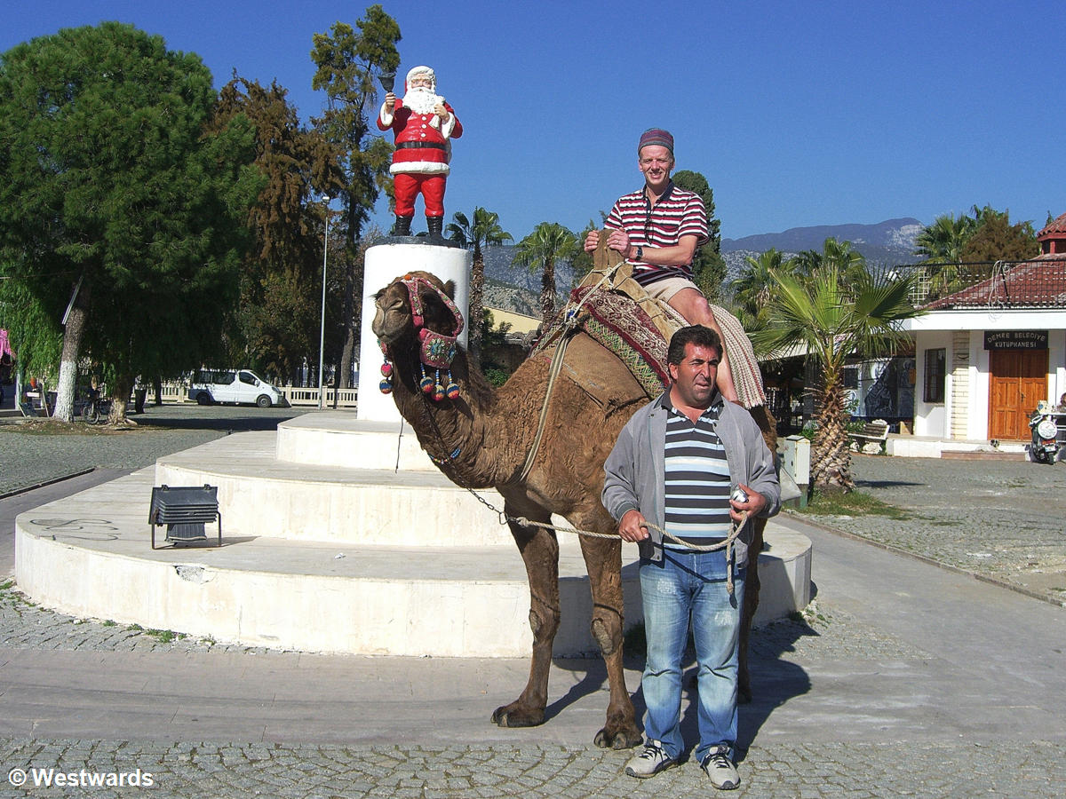 Santa Claus statue and tourist on a camel on a visit to Myra / Demre