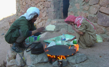 Two bedouins baking bread