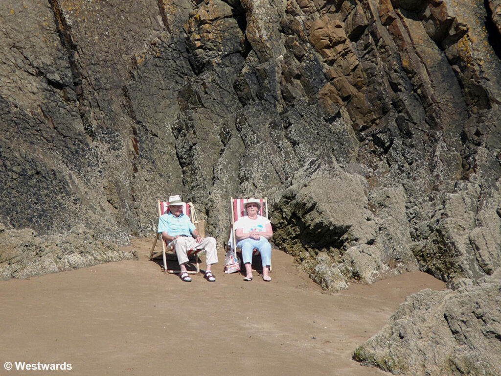 elderly couple in beach chairs with cliffs