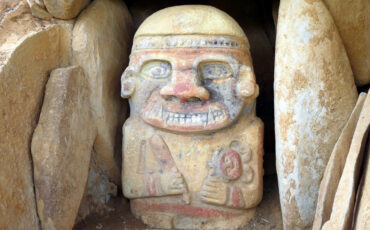 Scary looking stone figure with paintings in red and black