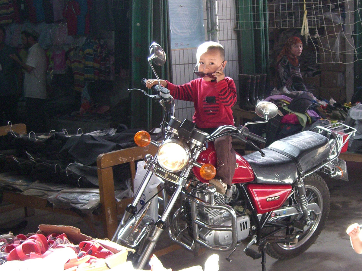 Uighur boy on a motor cycle